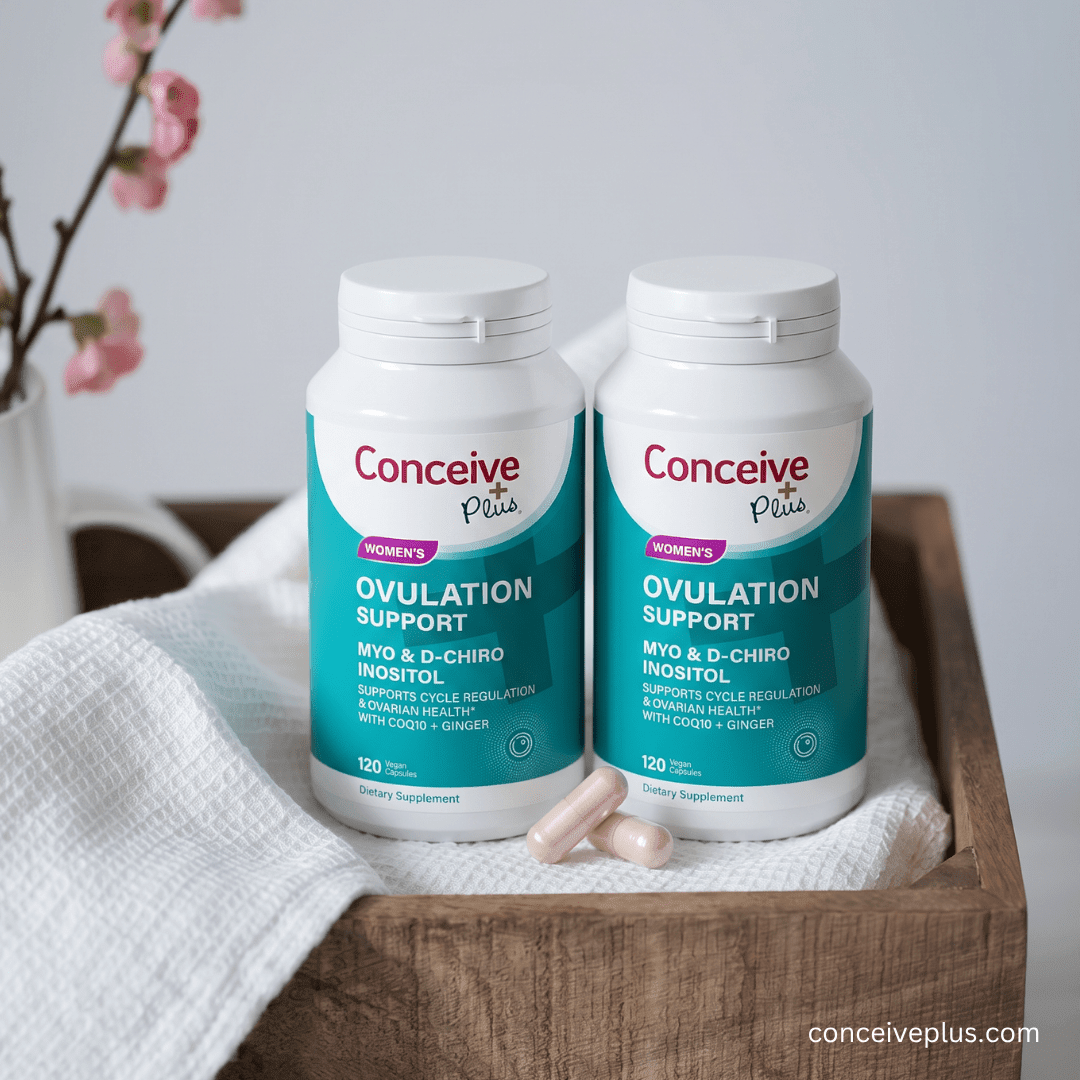 Two bottles of Conceive Plus ovulation support supplements on a wooden surface with a white background.