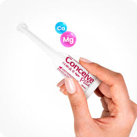 For Try Me Size - Fertility Lubricant Bundle the image female right hand entering the frame from the bottom and holding a Conceive Plus Fertility Lubricant 3x4g pre-filled applicator with its front side towards the camera on a white background. There are two bubbles in the upper middle part of the frame just above the applicator with blue bubble has chemical formula of Calcium as 'Ca' and the pink bubble has the chemical formula of Magnesium as 'Mg' written inside them.